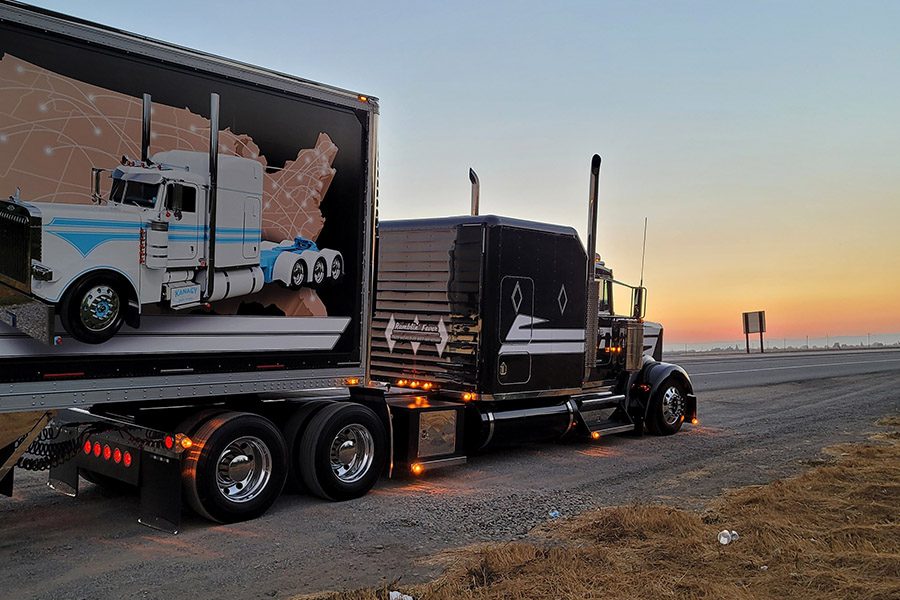 Amazing Feedback - Side View of a Large Black Truck Driving Down the Highway By the Water at Sunset